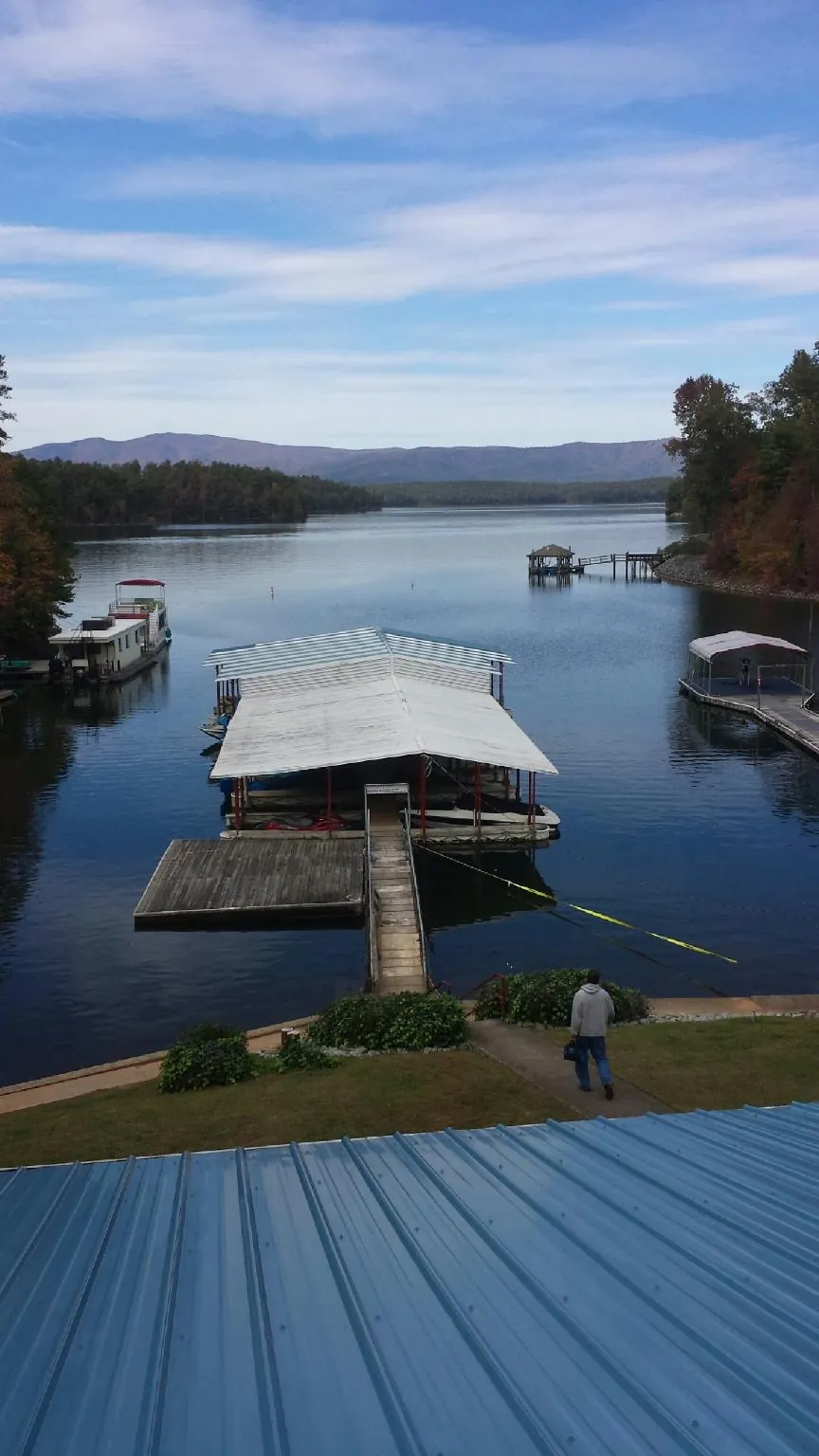 View across a lake from a newly installed blue metal roof in Tuscarora