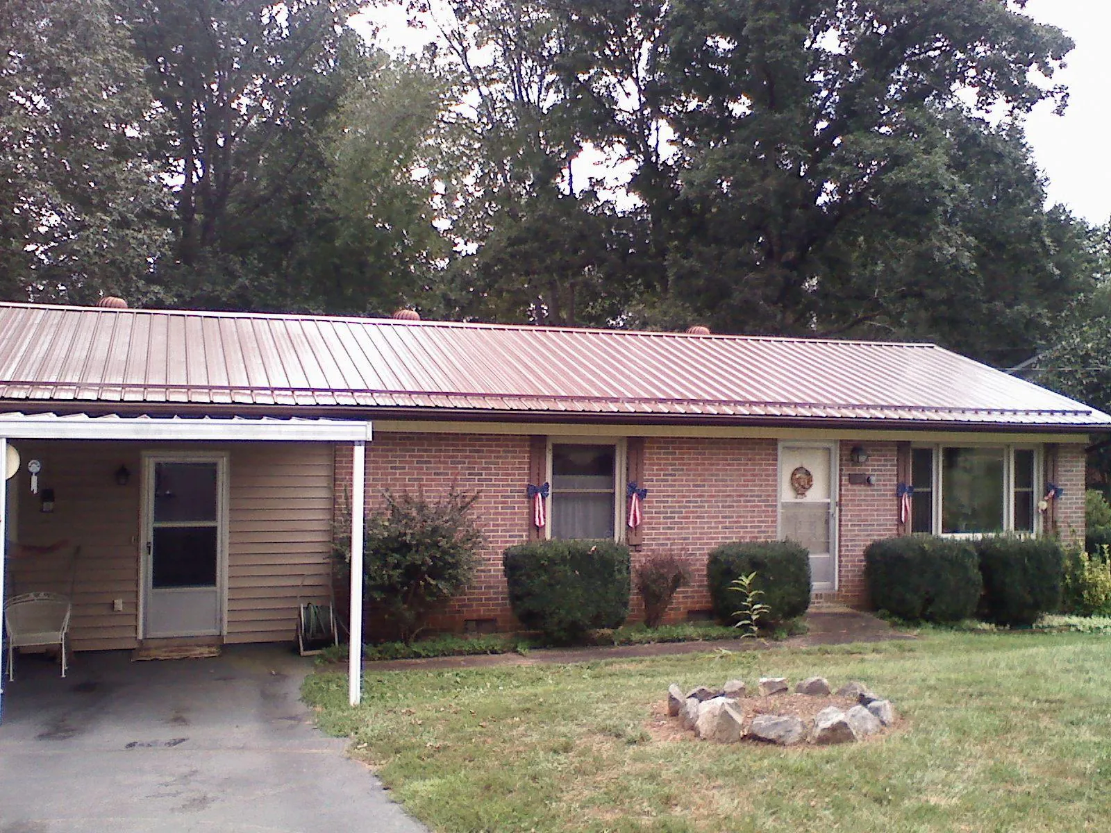 Bronze metal roof and carport on a brick ranch home — Roof Repair work by our crew in Tuscarora